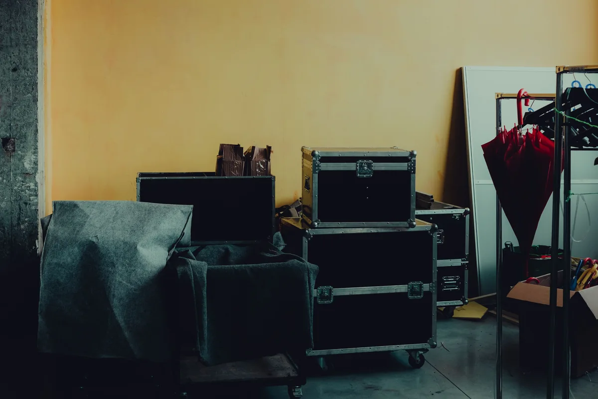 Black protective transport cases beside padded items in a storage area.